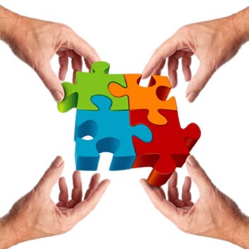 Four hands holding puzzle pieces that link together