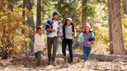 African American Family Walking Through Fall Woodland