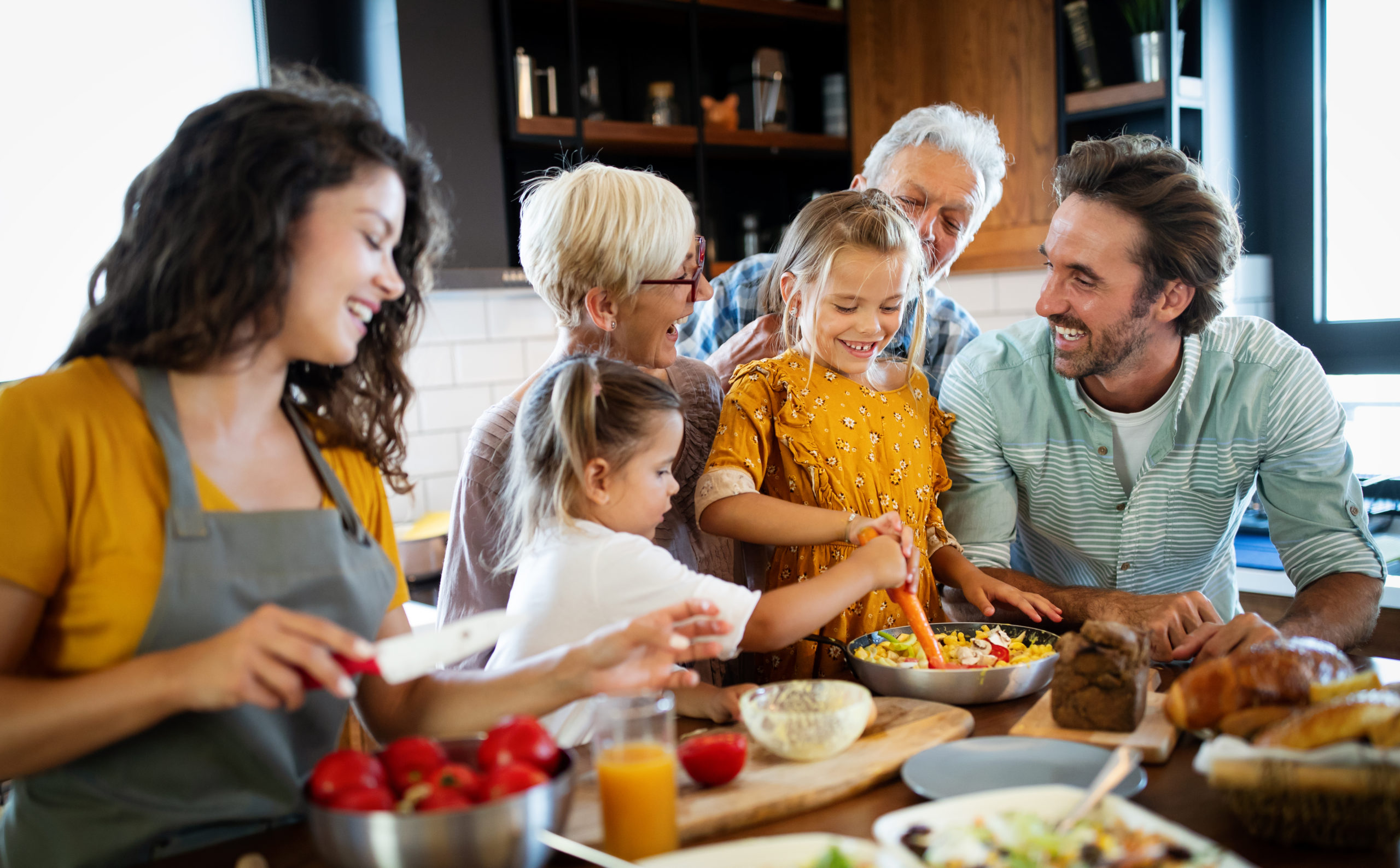 Cheerful family spending good time together while cooking in kitchen