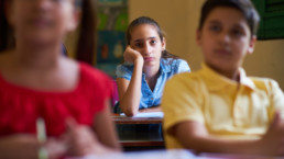 Young people and education. Group of hispanic students in class at school during lesson. Girl with anxiety, bored female student