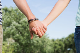 Young couple in the park holding hands on a sunny day