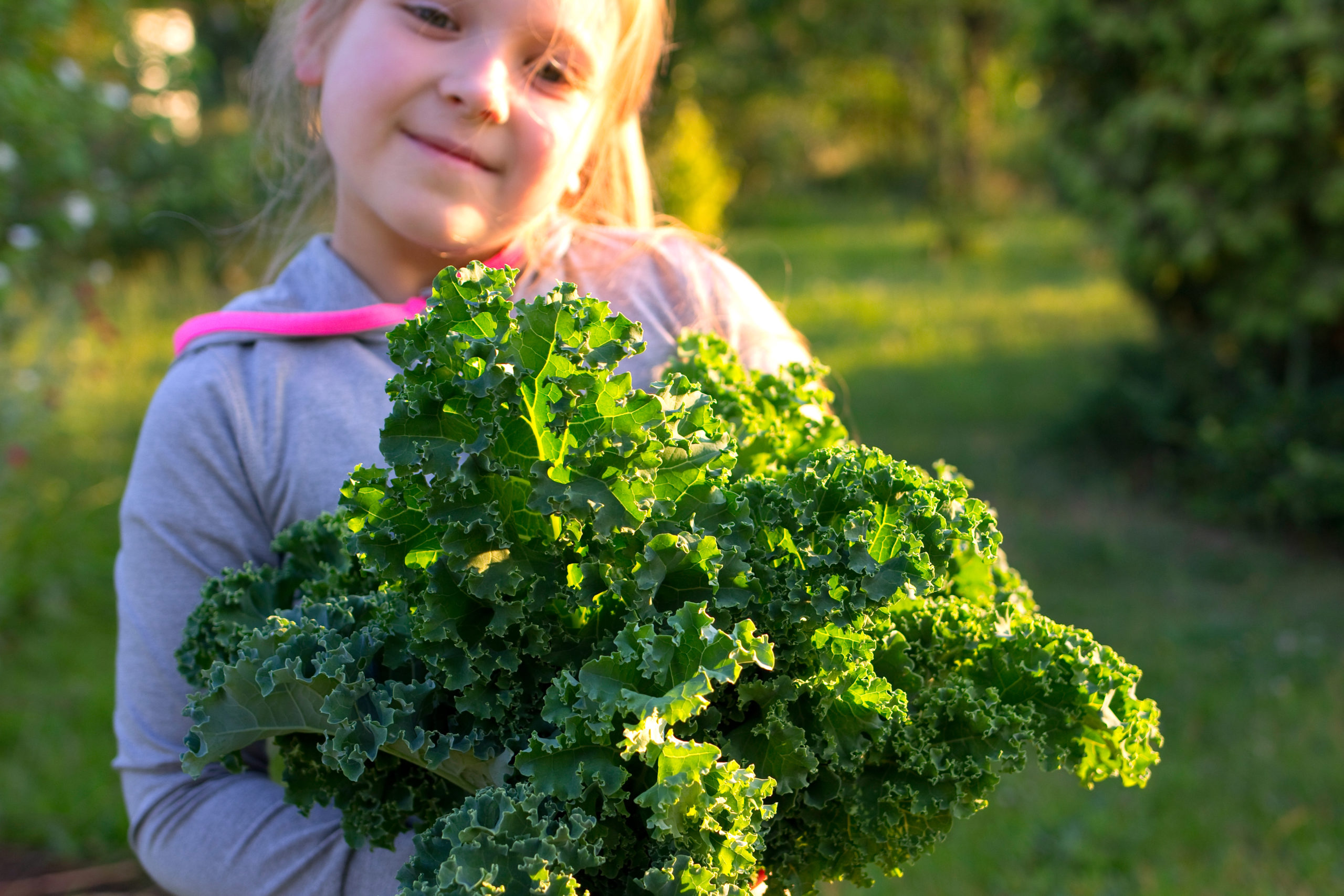 young girl holding kale