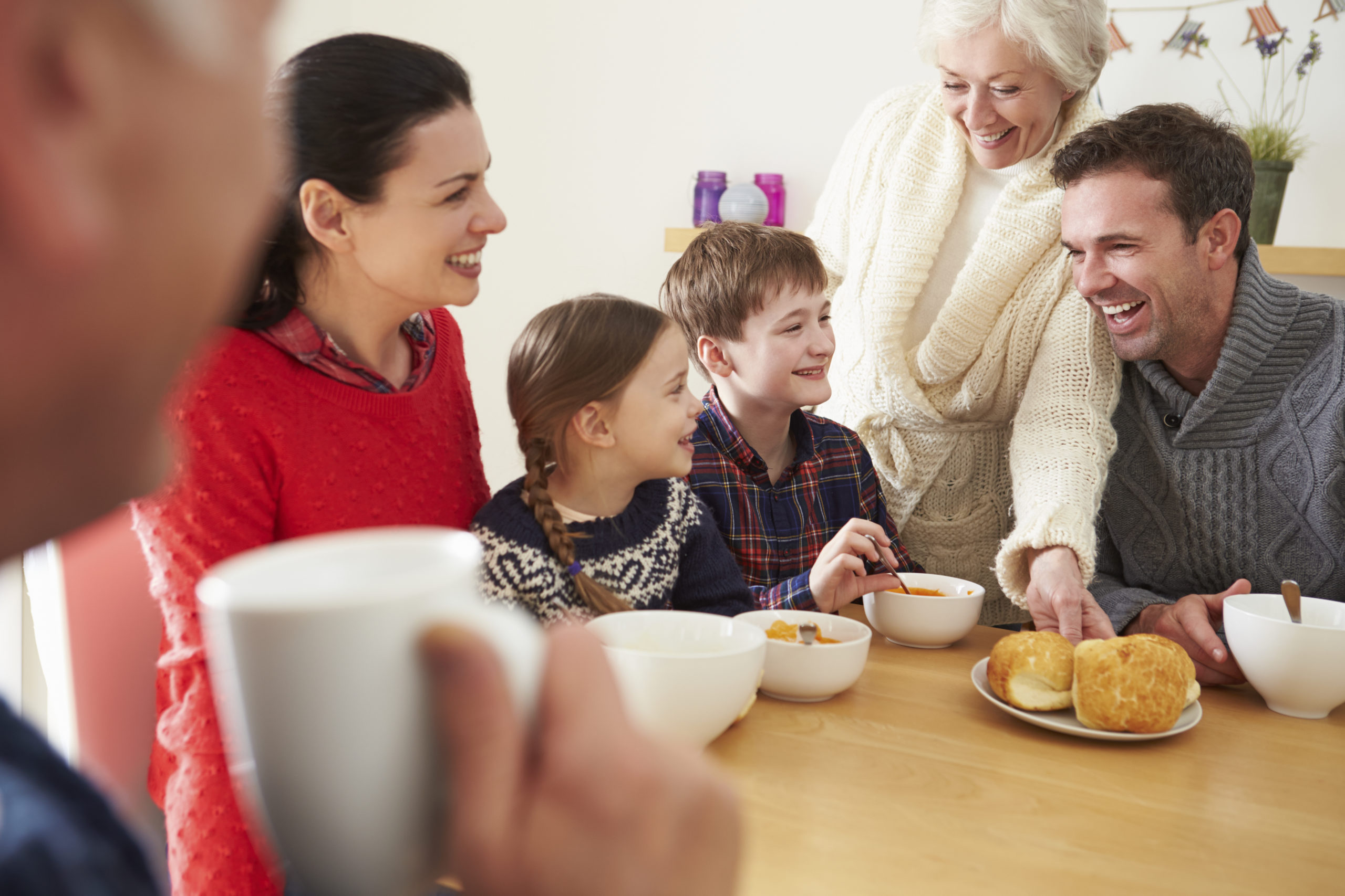 Multi Generation Family Eating Lunch At Kitchen Table