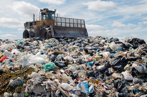 The bulldozer buries food and industrial wastes