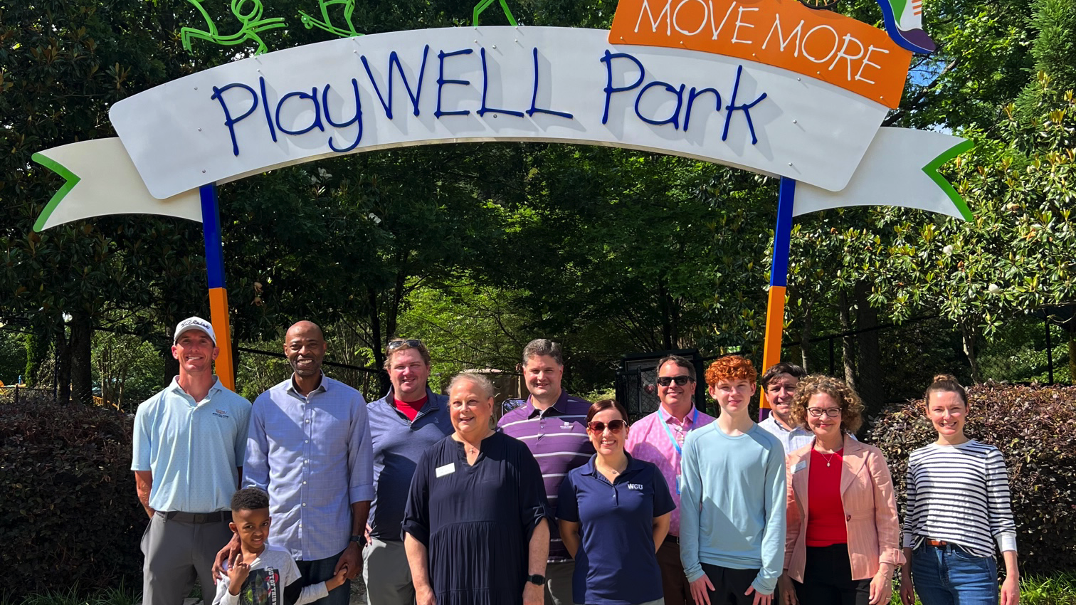 The Leadership Raleigh team standing outside the Poe Center's PlayWELL Park with the Poe Centers Executive Director Ann.