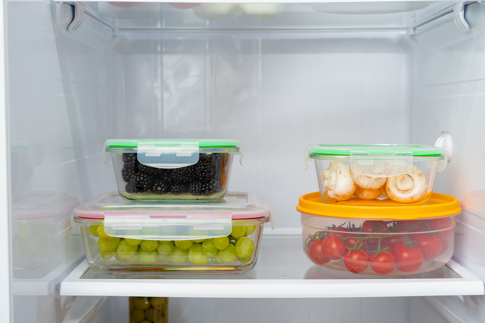 Storage containers with fresh food in a fridge close up