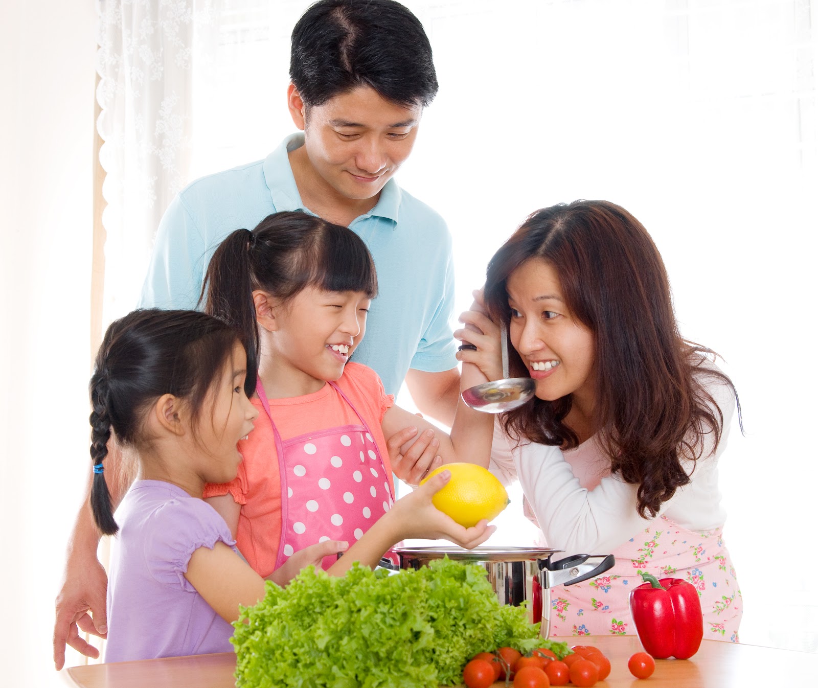 Father and mother assist young daughters in making soup