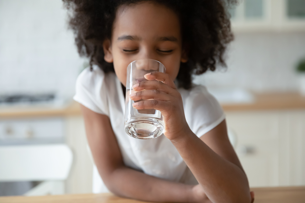 A child enjoying a glass of water.