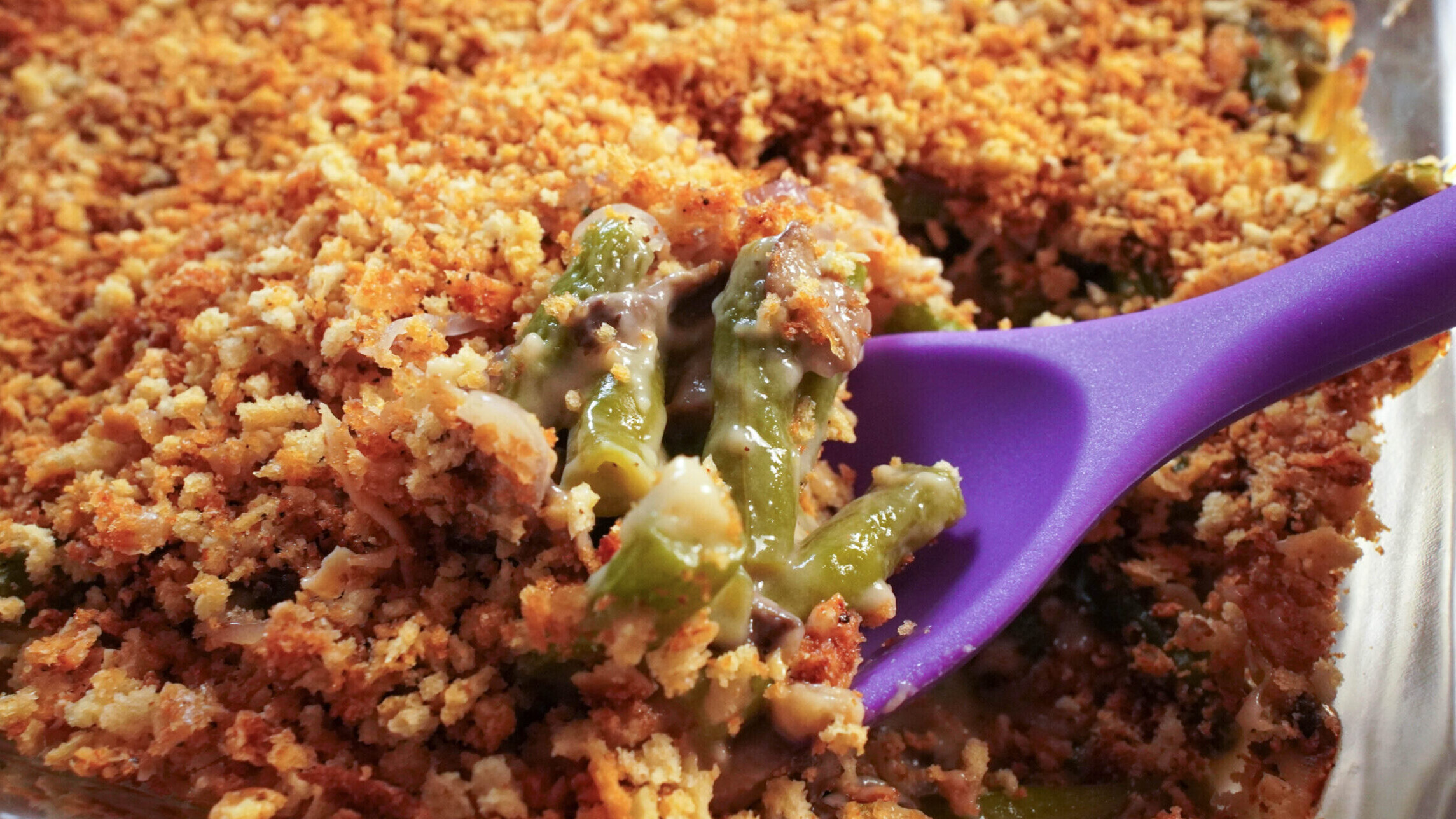 Green bean casserole with a purple spoon in the casserole.