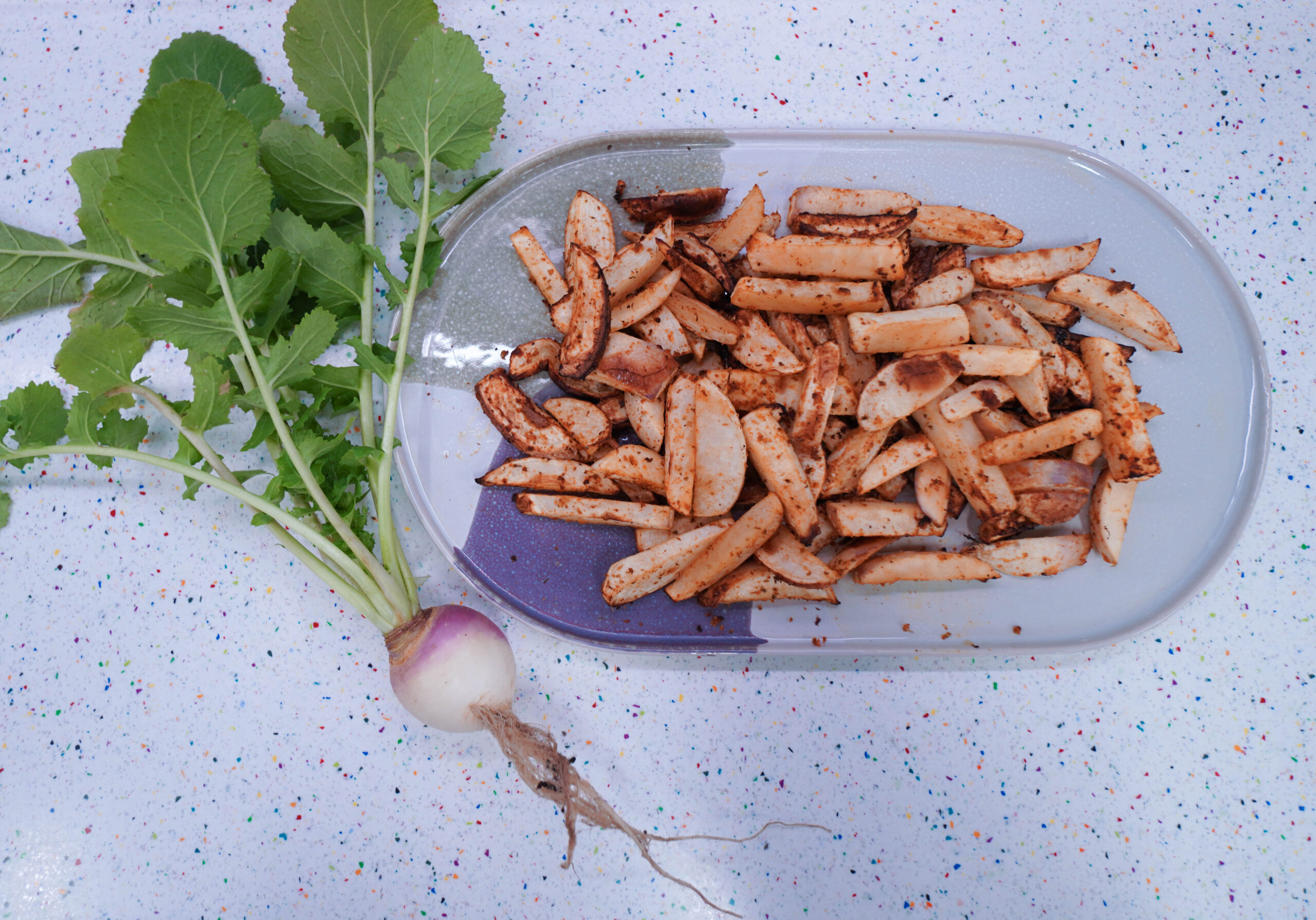 Fresh turnip next to a plate of air fried turnips.