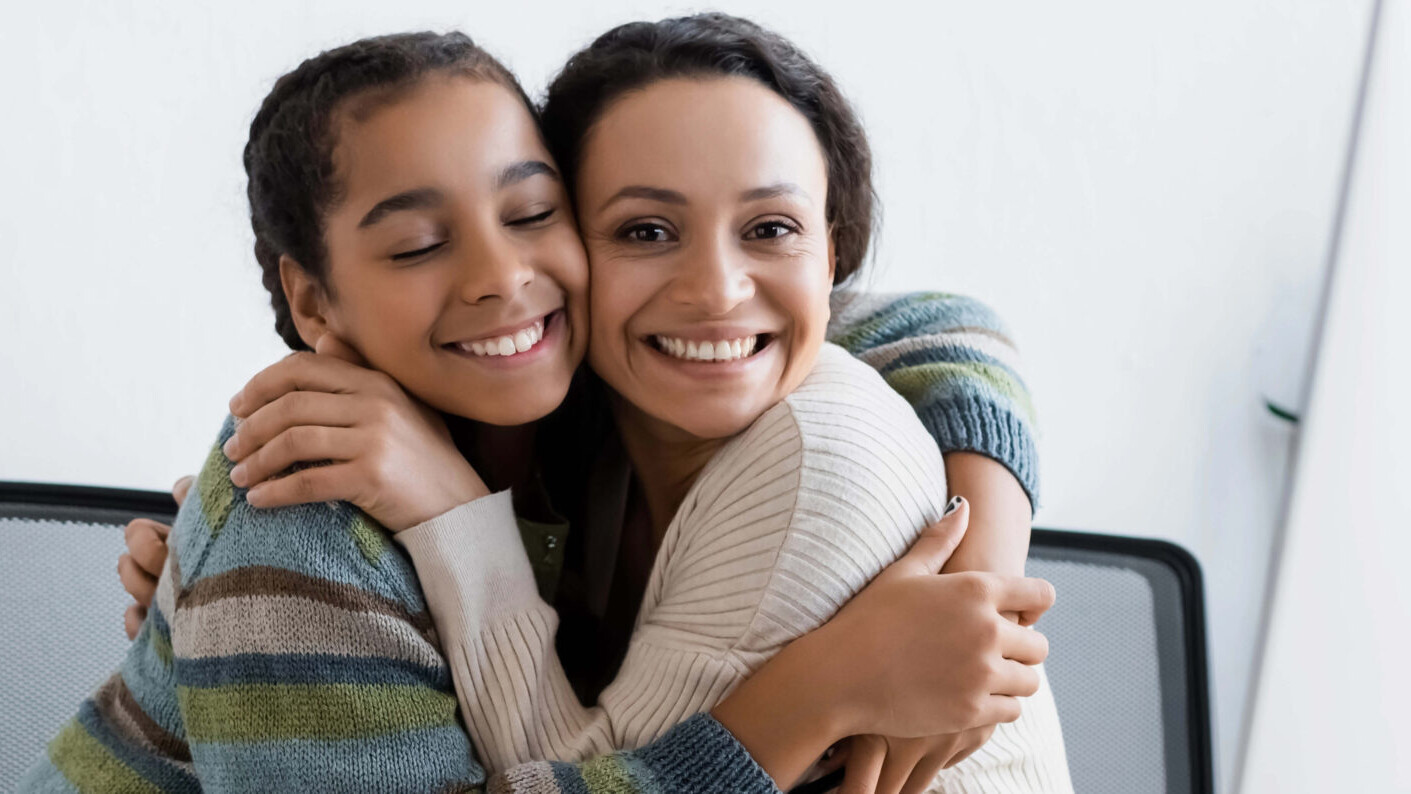 mother hugging tween daughter