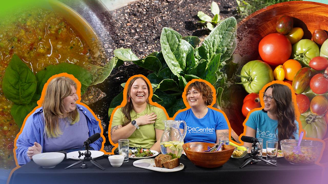 Four people laughing at a table with garden produce and soup behind them.